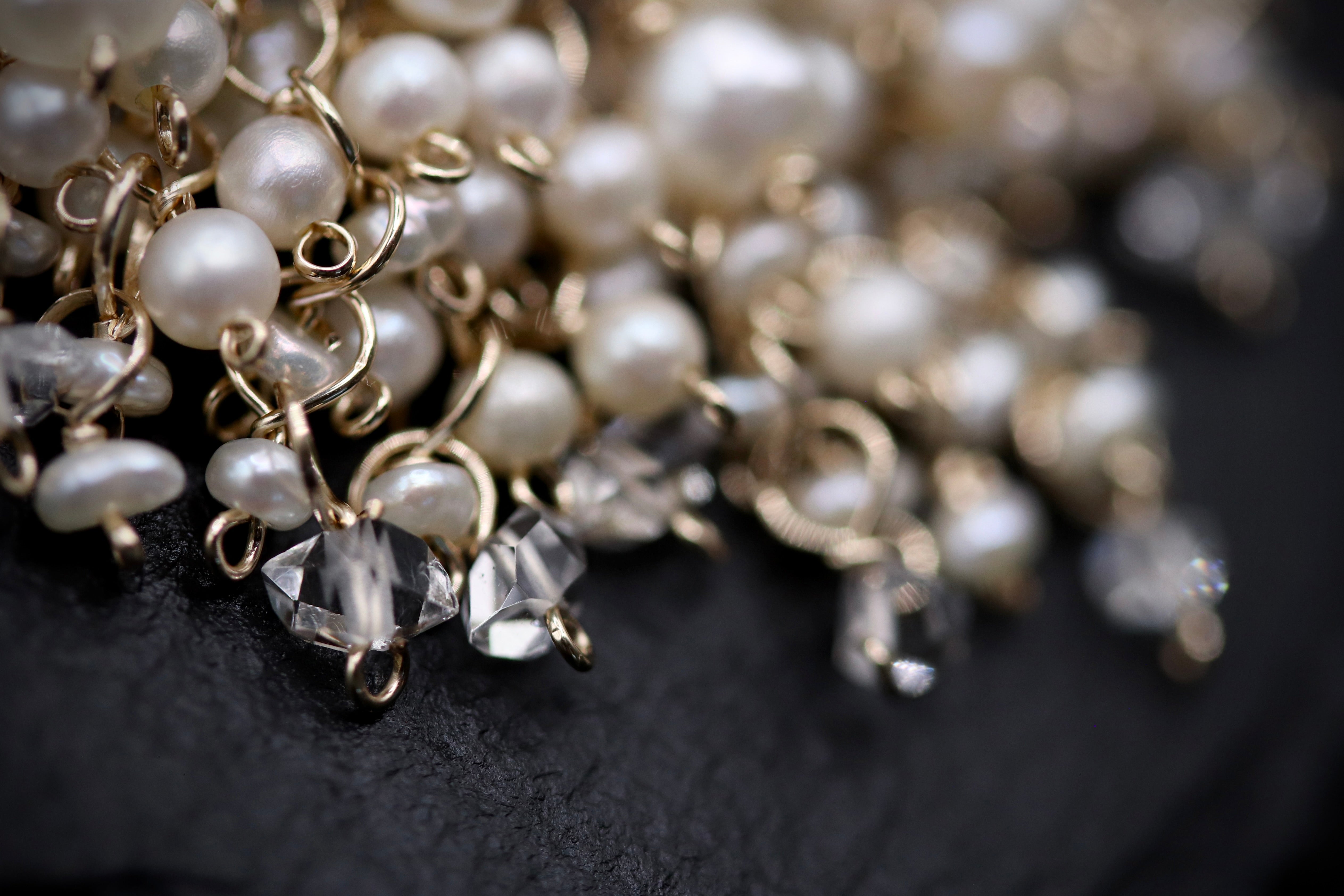 A close-up view of a collection of delicate, white pearls and clear gemstones, such as diamonds, arranged in a visually appealing manner.