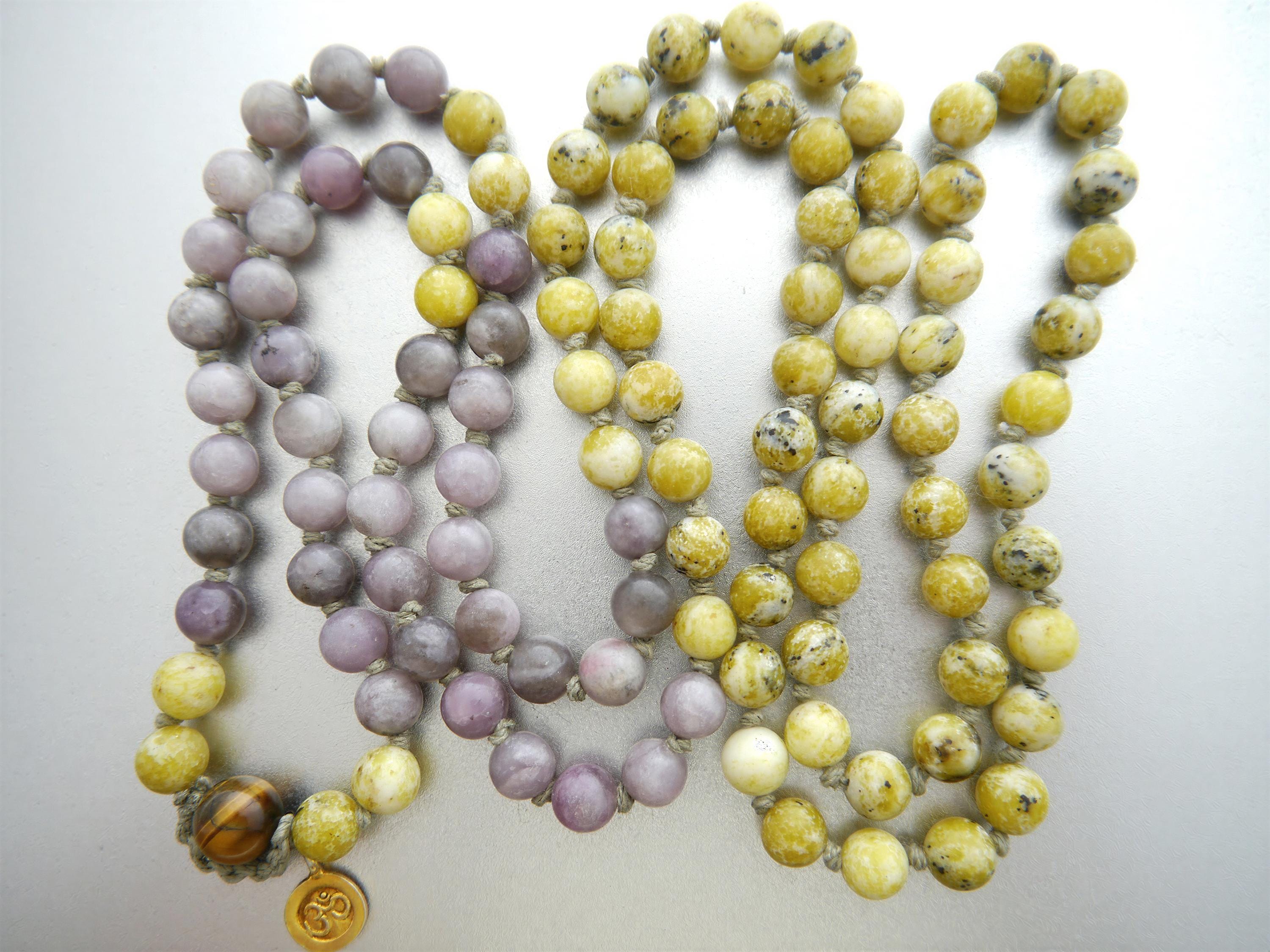 a collection of colorful beaded necklaces, with a mix of purple and yellow beads. The necklaces are arranged in a way that they appear to be hanging together, creating a visually appealing display.