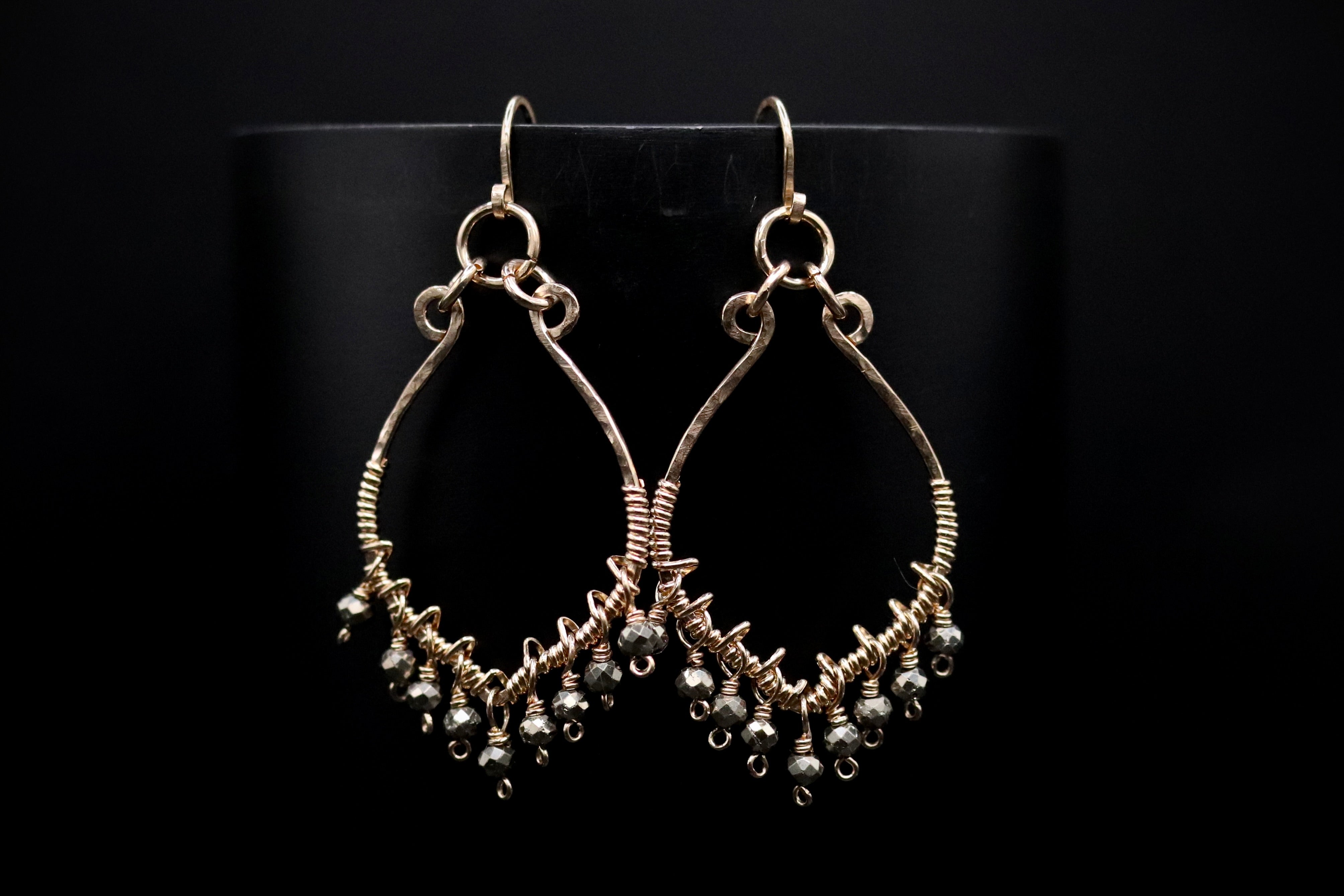 A pair of elegant earrings with a black background.