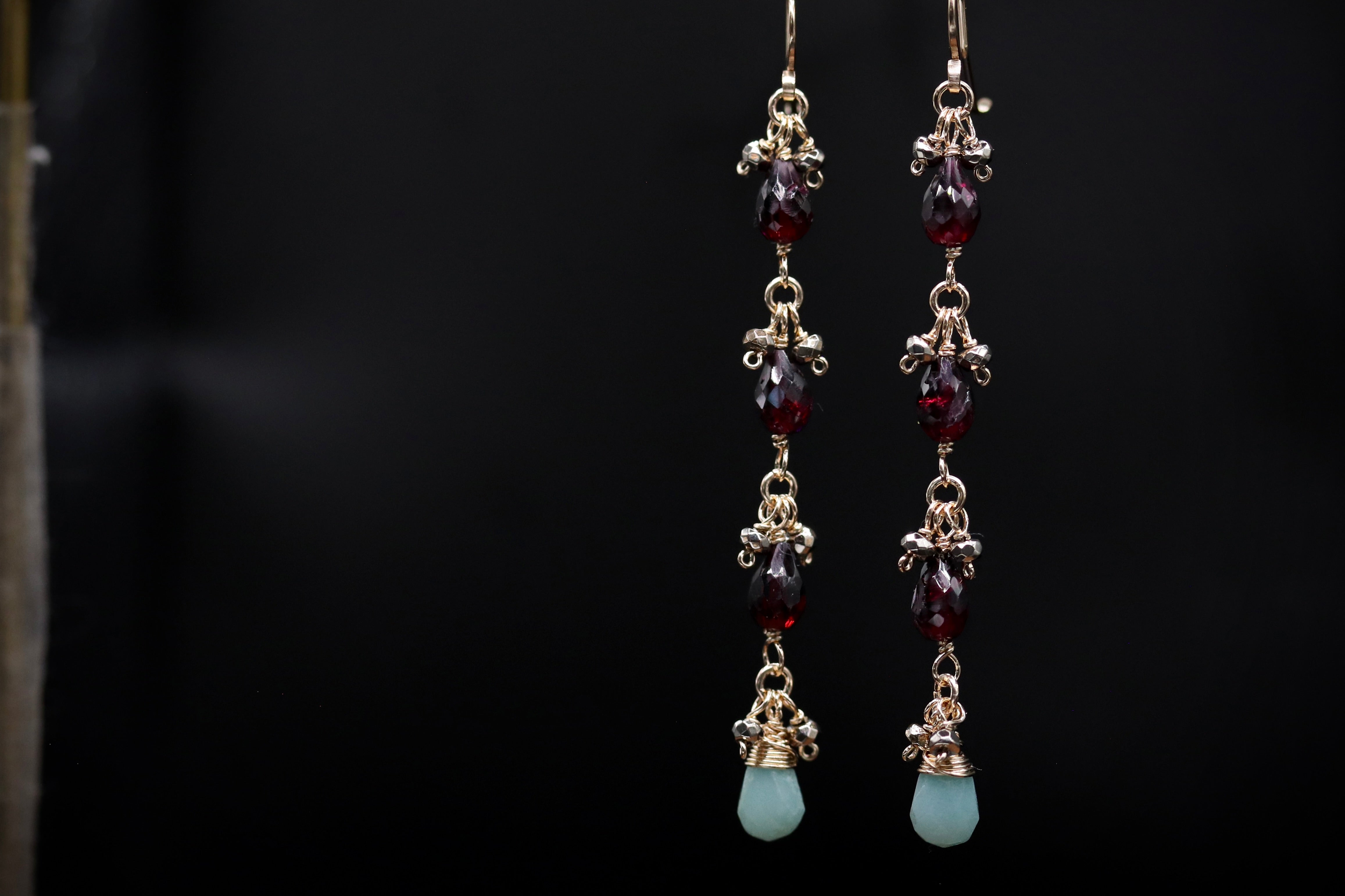 A pair of elegant earrings with a dark background.