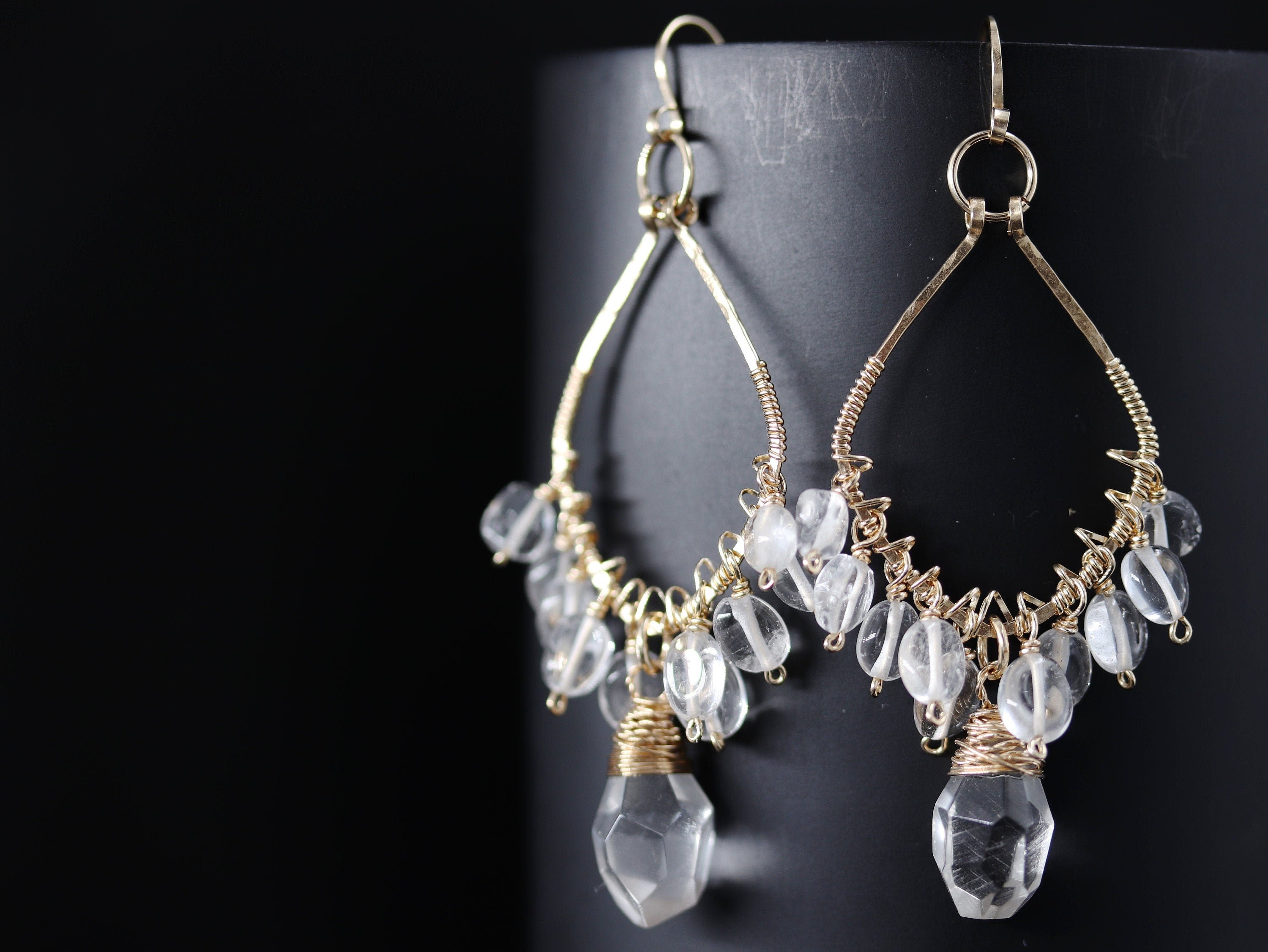 May include: Gold wire earrings with clear quartz crystals and a teardrop-shaped crystal dangle.