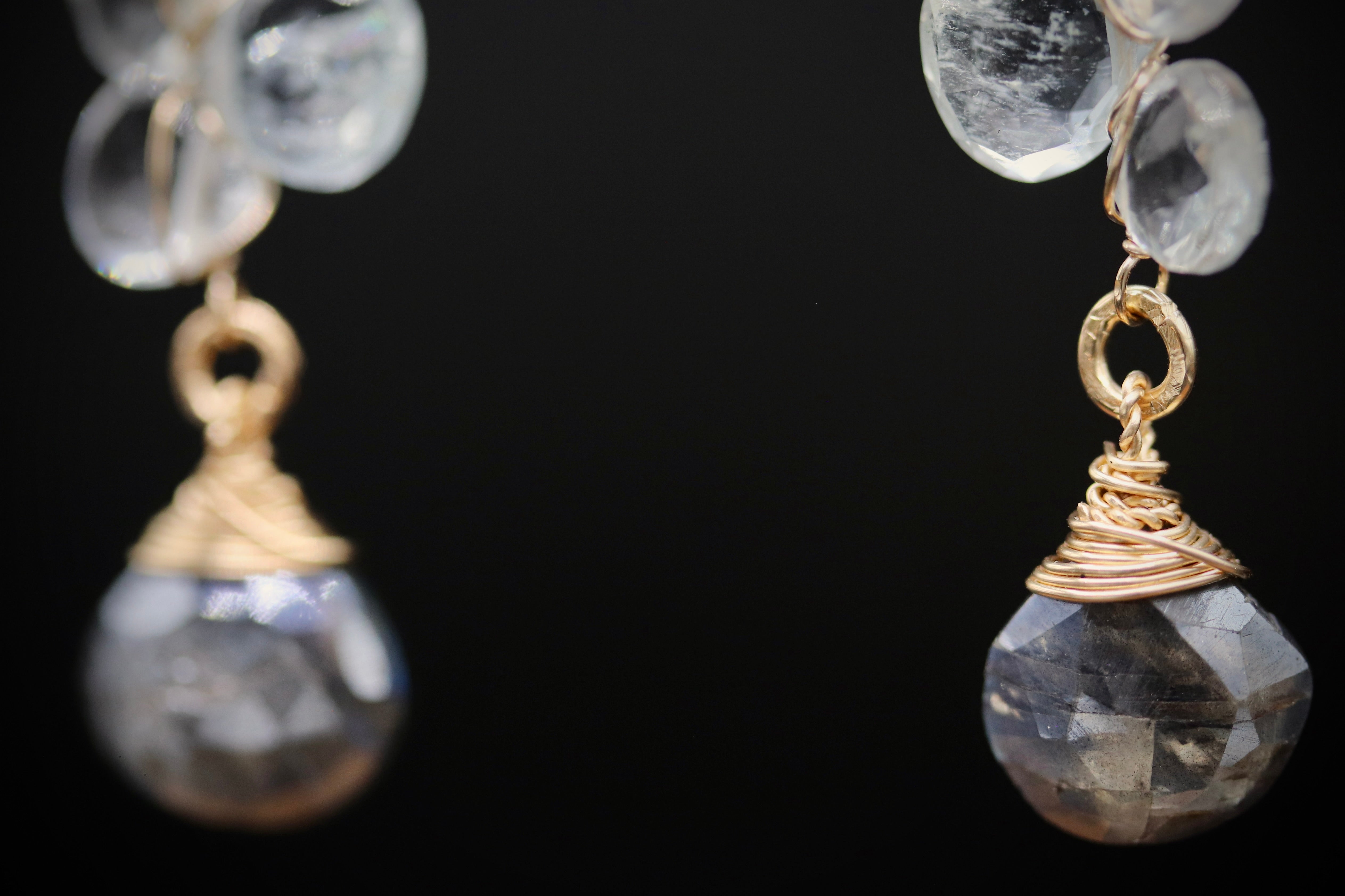 A pair of elegant earrings with clear gemstone pendants and gold-colored metal accents.