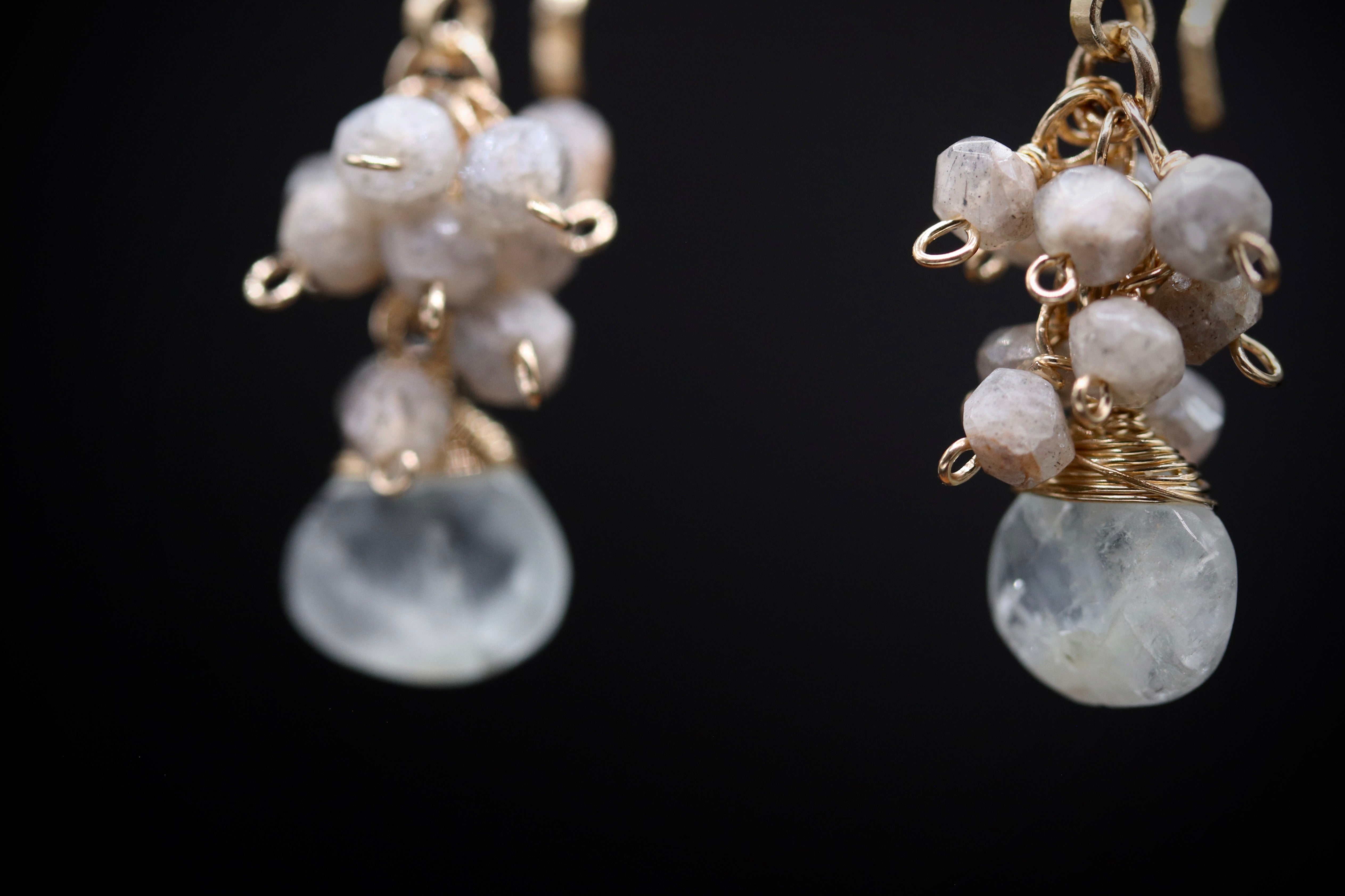 A pair of elegant earrings with white stones and gold-colored metal accents.