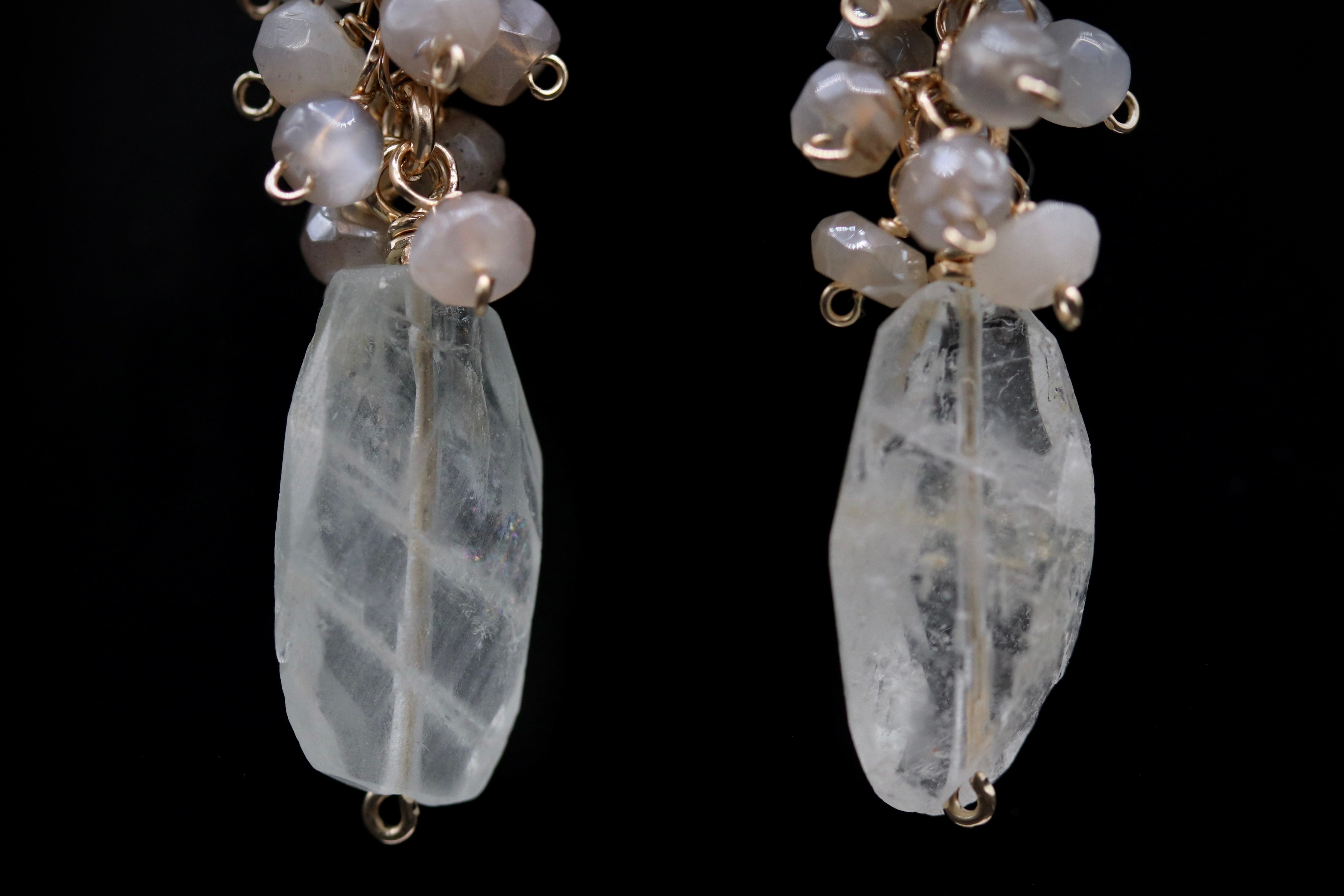 A pair of elegant earrings with clear crystal pendants and small white beads.
