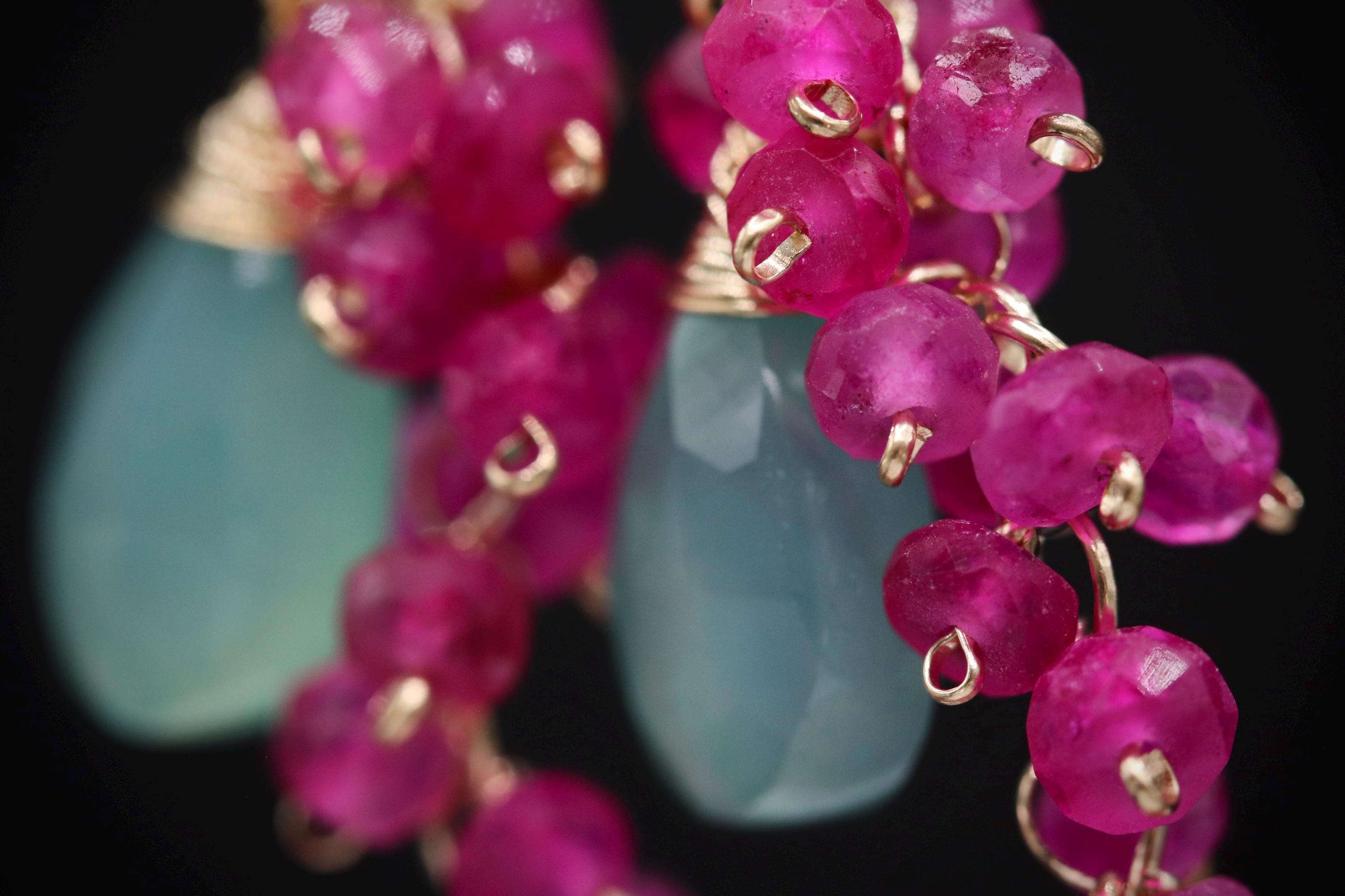 A close-up view of a delicate necklace with a combination of blue and pink gemstone beads, creating a vibrant and eye-catching piece of jewelry.