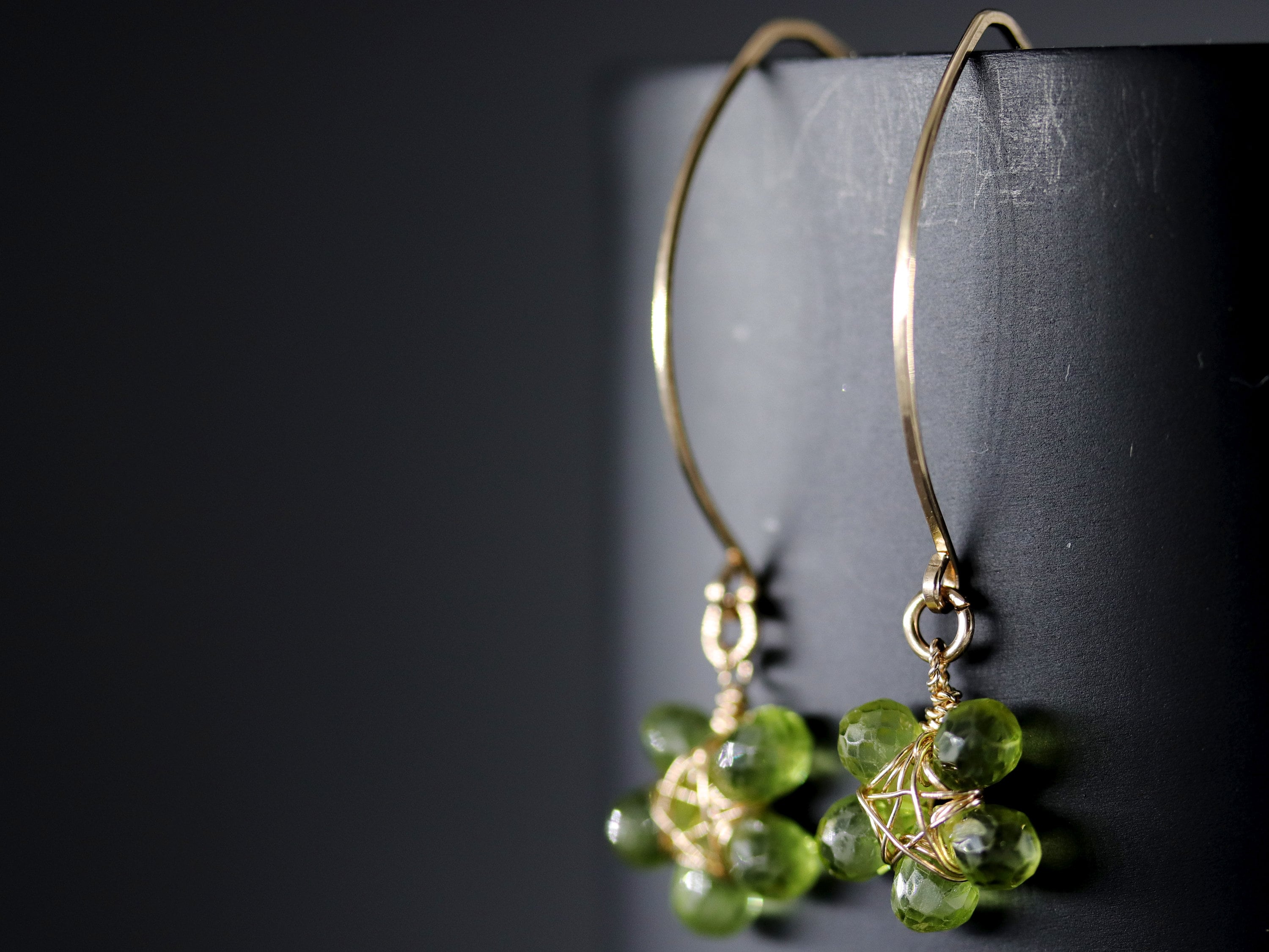 May include: Gold earrings with green gemstone flower accents.