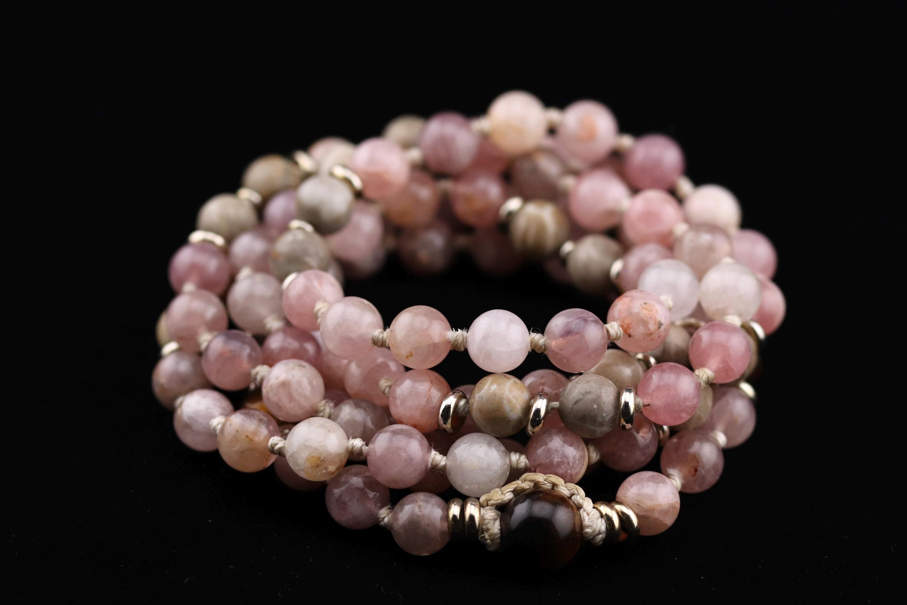 A collection of beaded bracelets with a variety of colors and sizes, arranged in a circular pattern against a black background.