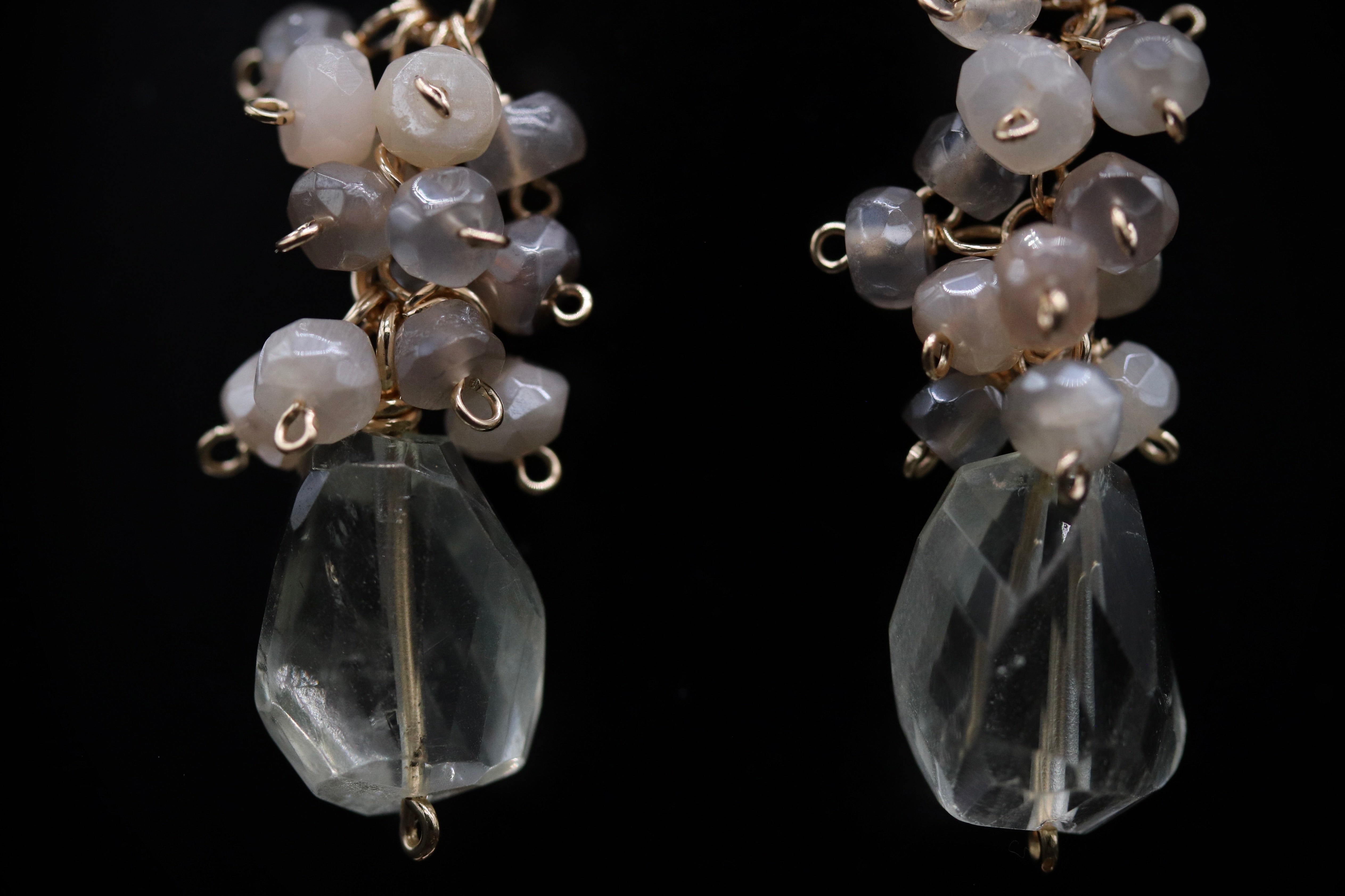 A pair of elegant earrings with clear crystal beads and metal chains or wires attached to them.