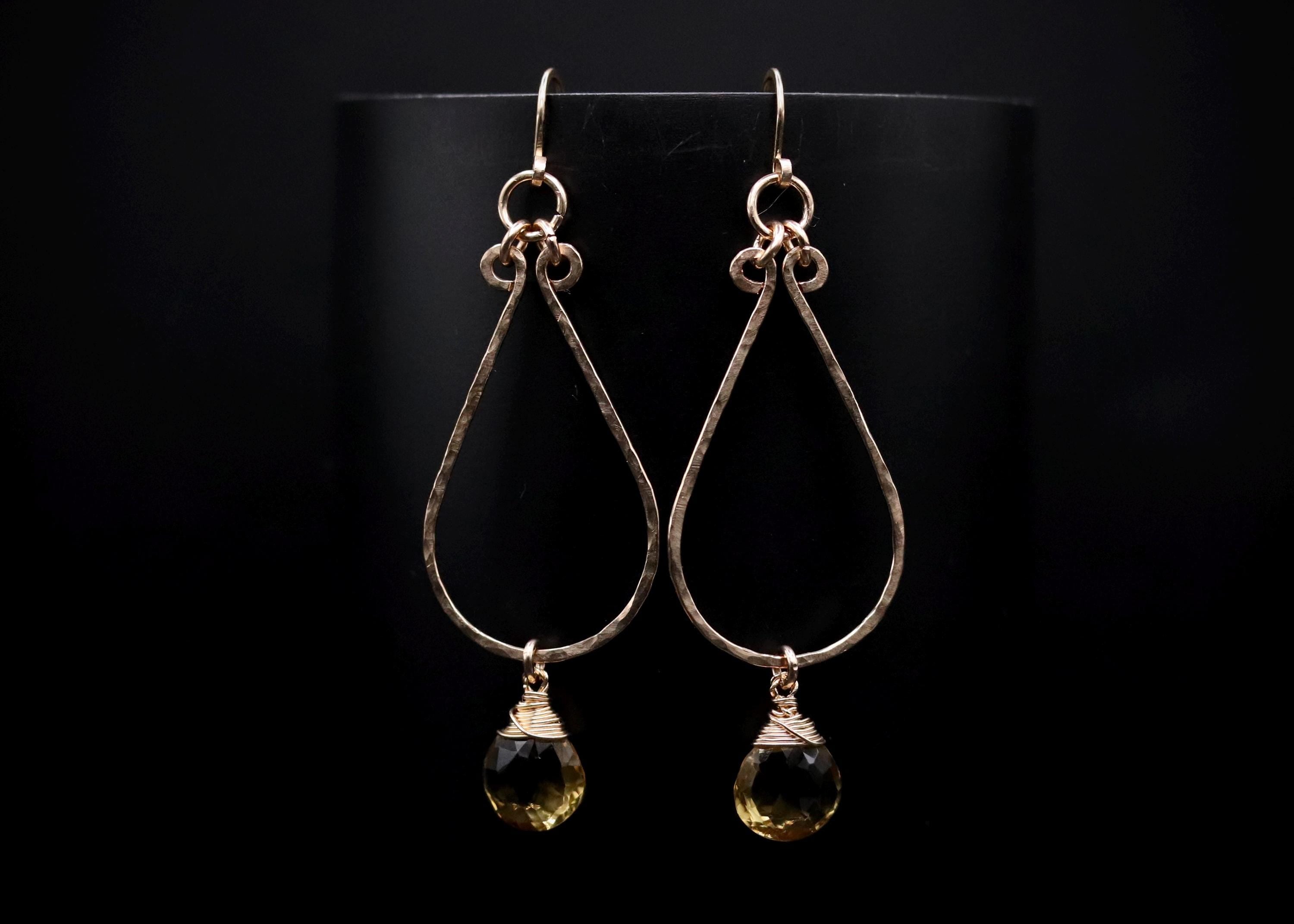 A pair of elegant earrings with a dark background.
