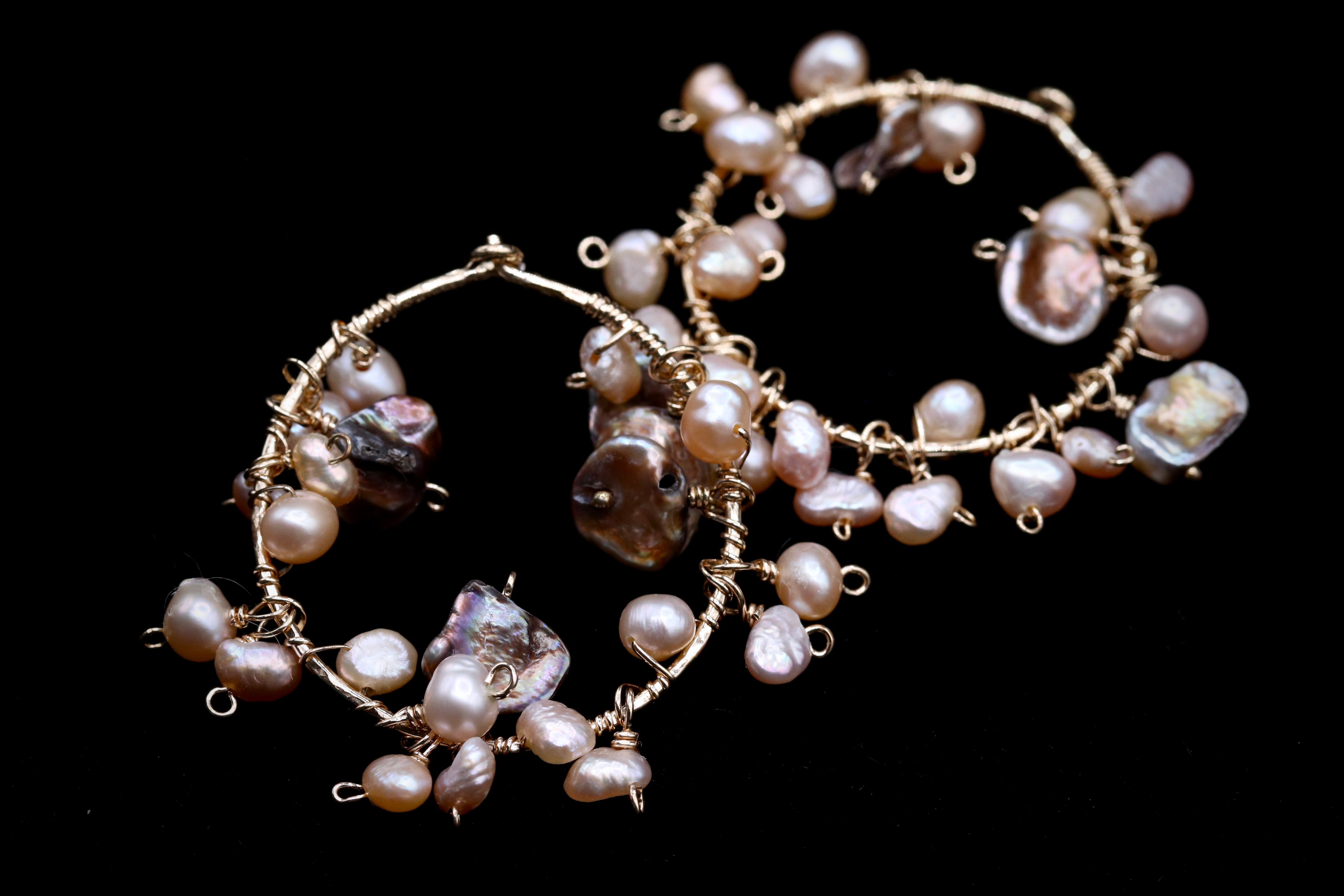 a pair of earrings made of wire and pearls, with the pearls hanging from the wire and the earrings themselves.