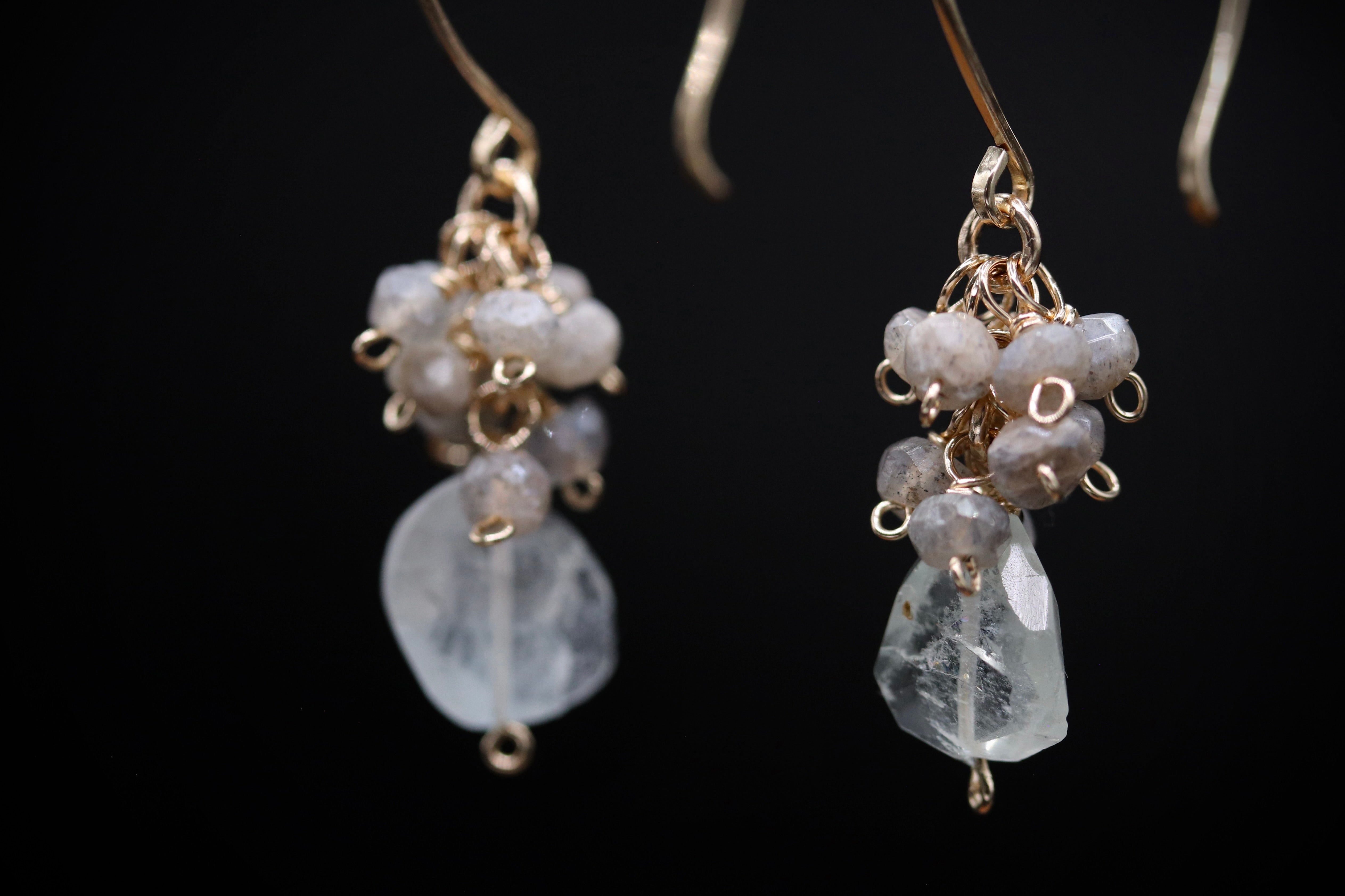 A pair of elegant earrings with clear gemstone accents and metal chains hanging from the ear hooks.