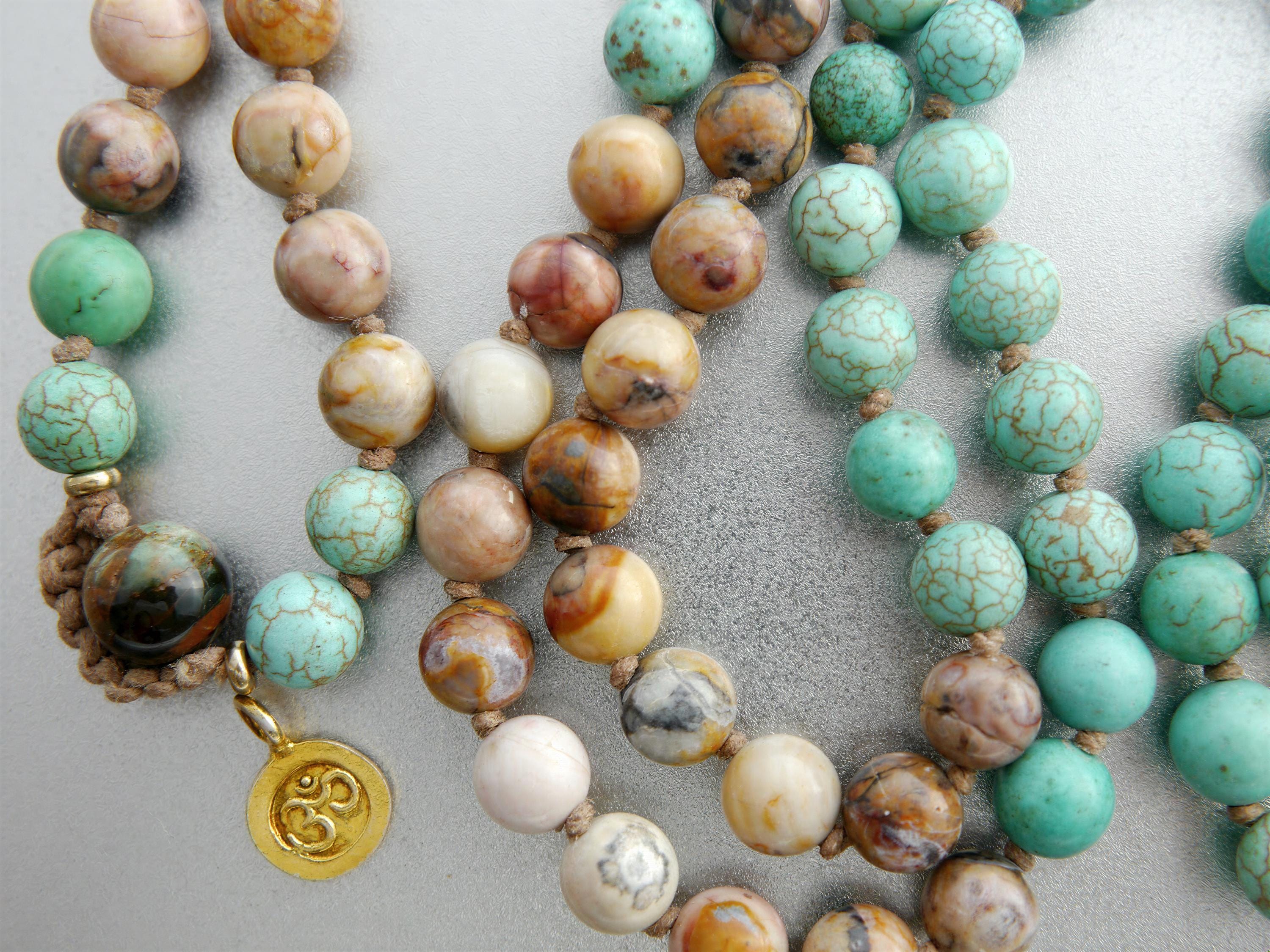 a collection of colorful beaded necklaces and bracelets, featuring various shades of turquoise, white, and brown stones.