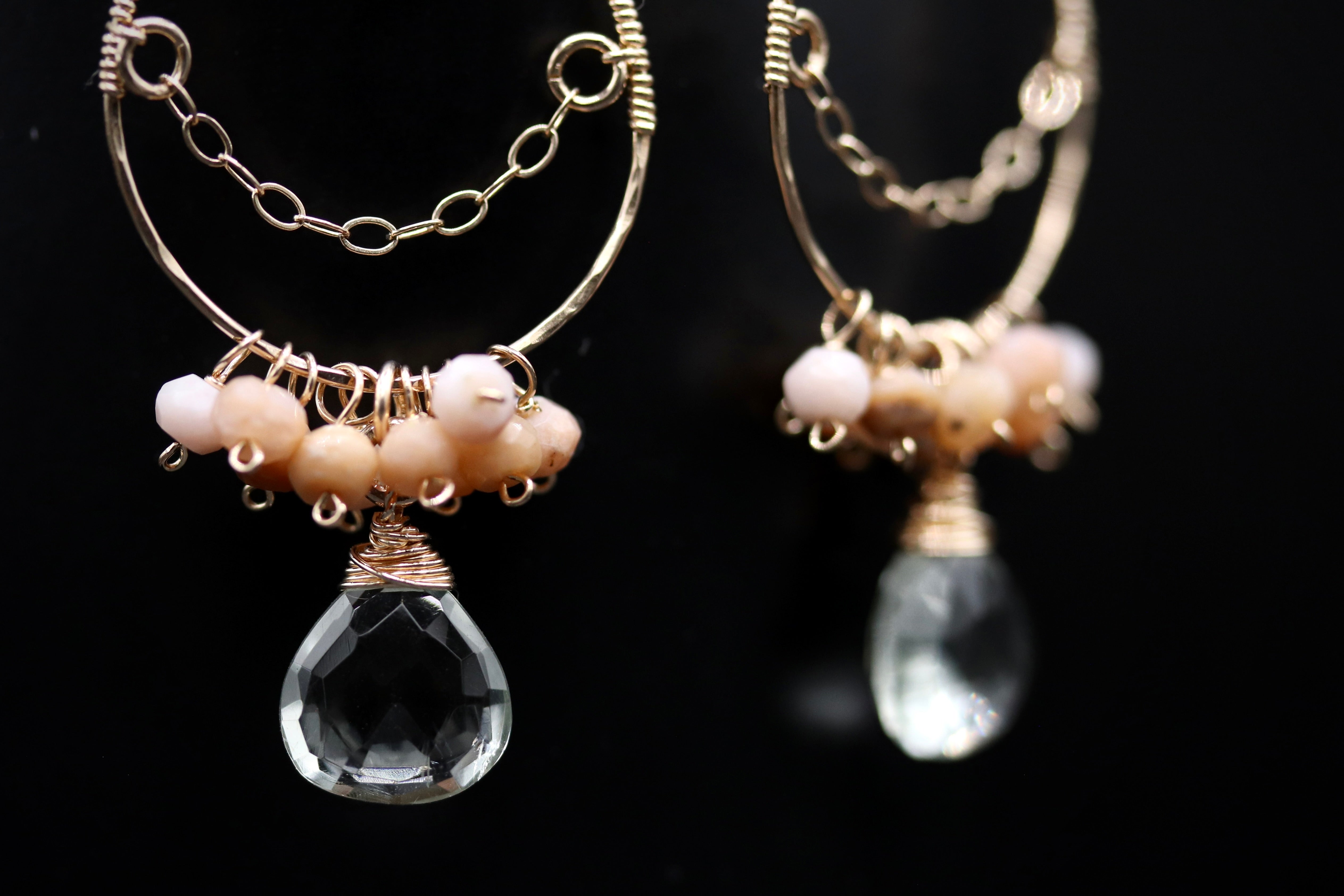 A pair of elegant earrings with clear gemstone drops and metal chains.