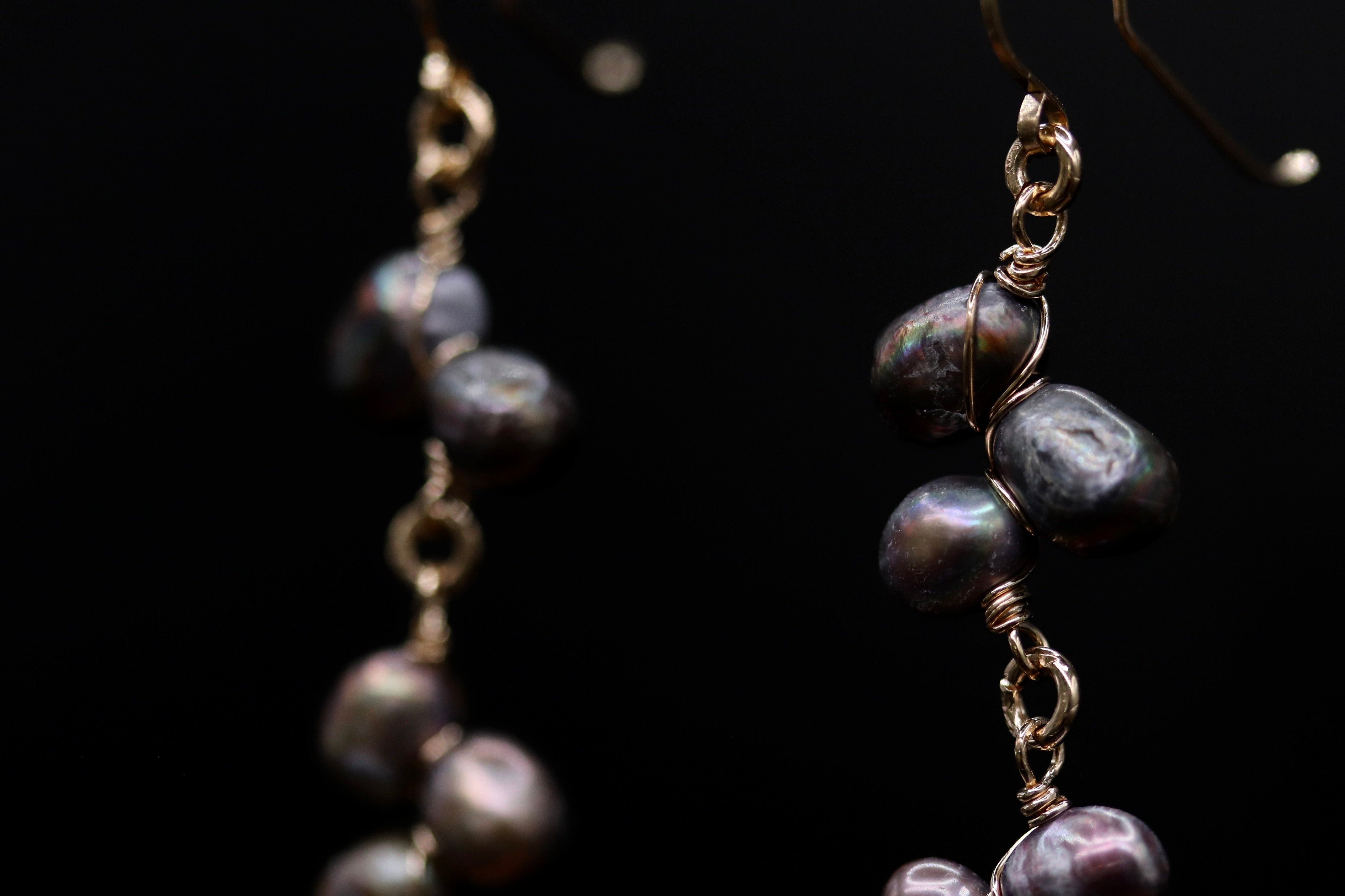 A close-up view of a pair of earrings with a dark background.